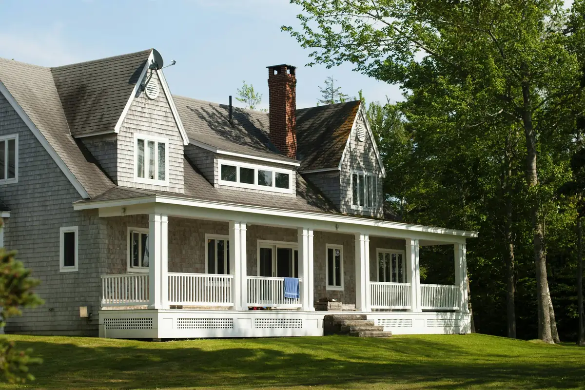 Countryside house exterior near green trees in daylight