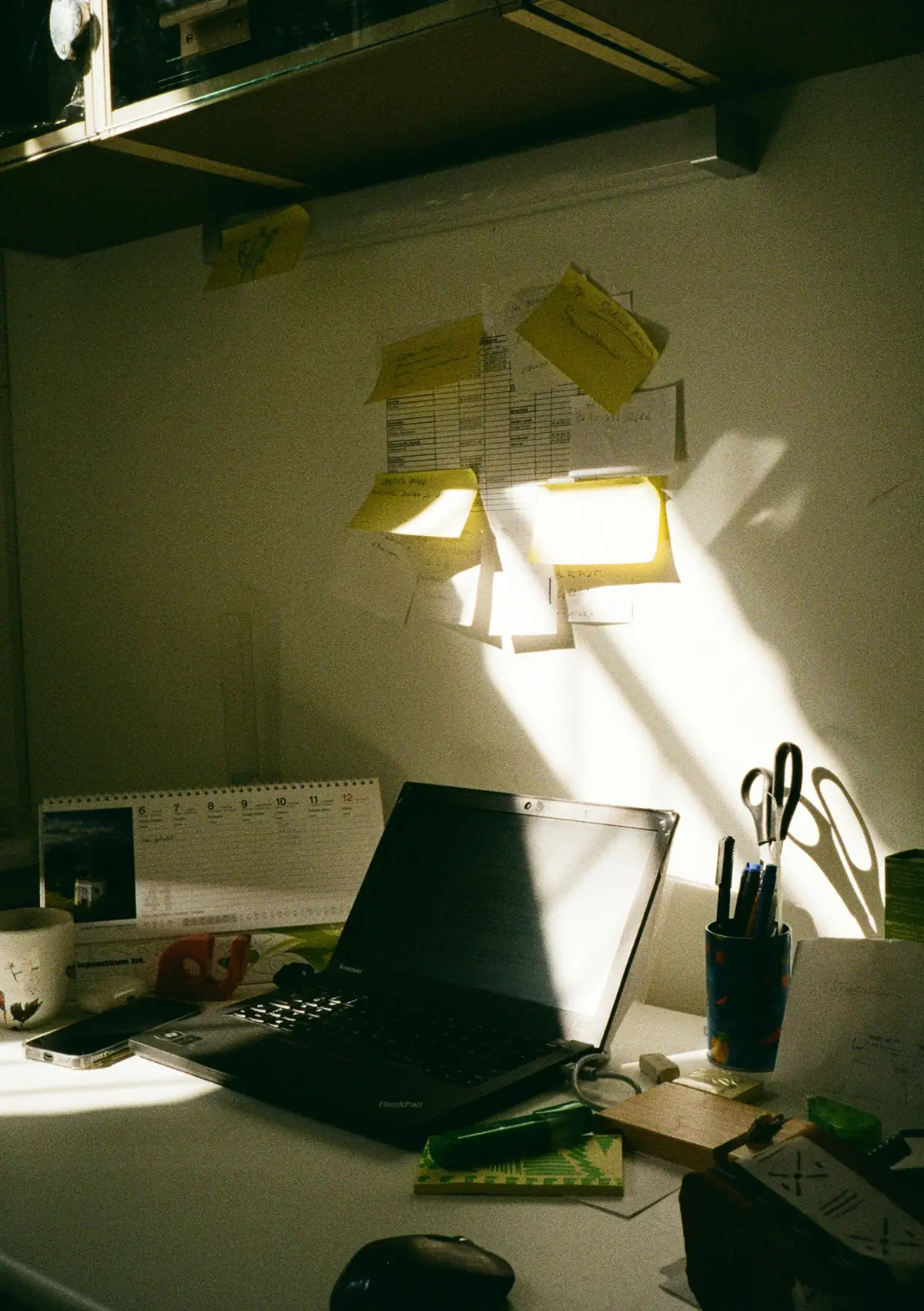 Laptop open on a desk in morning sunlight