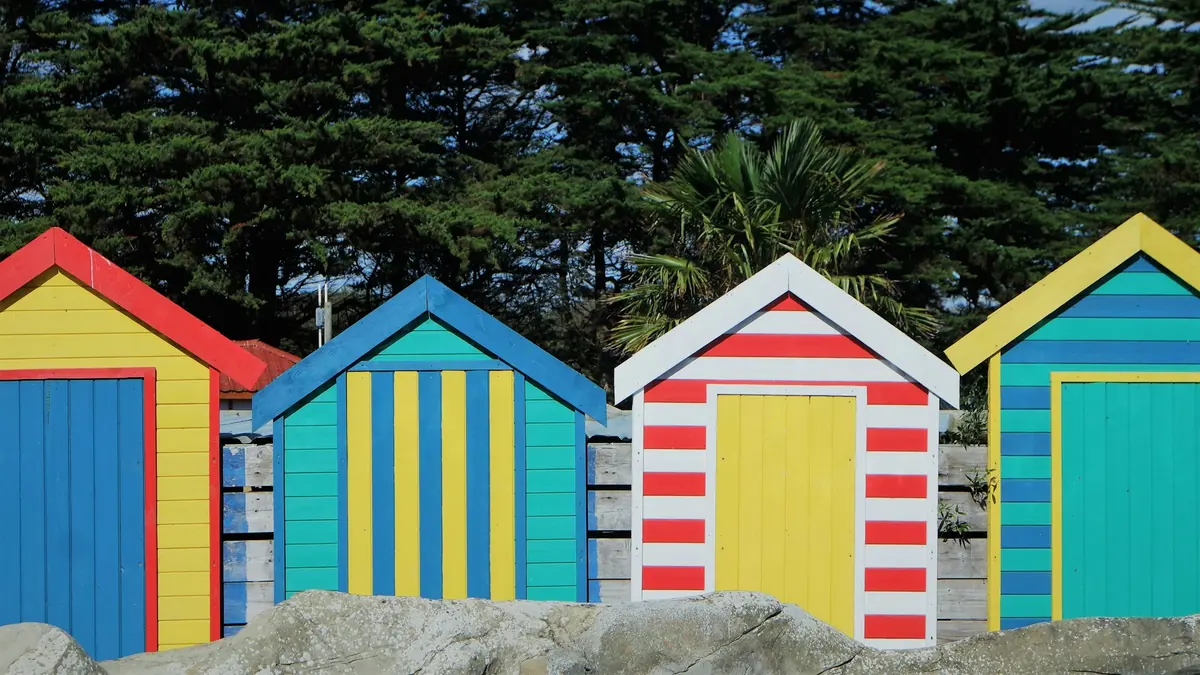 A row of colorful beach huts sitting next to each other
