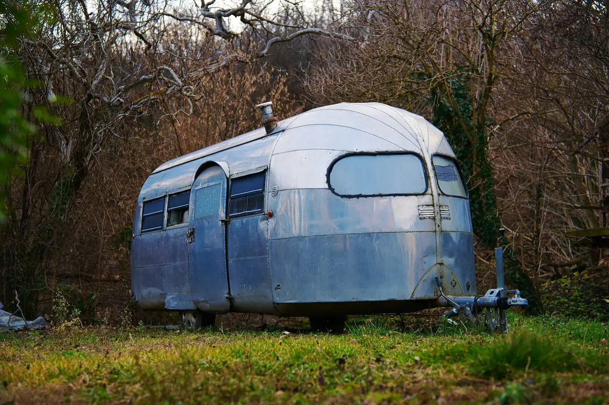 A vintage silver travel trailer parked in a grassy field