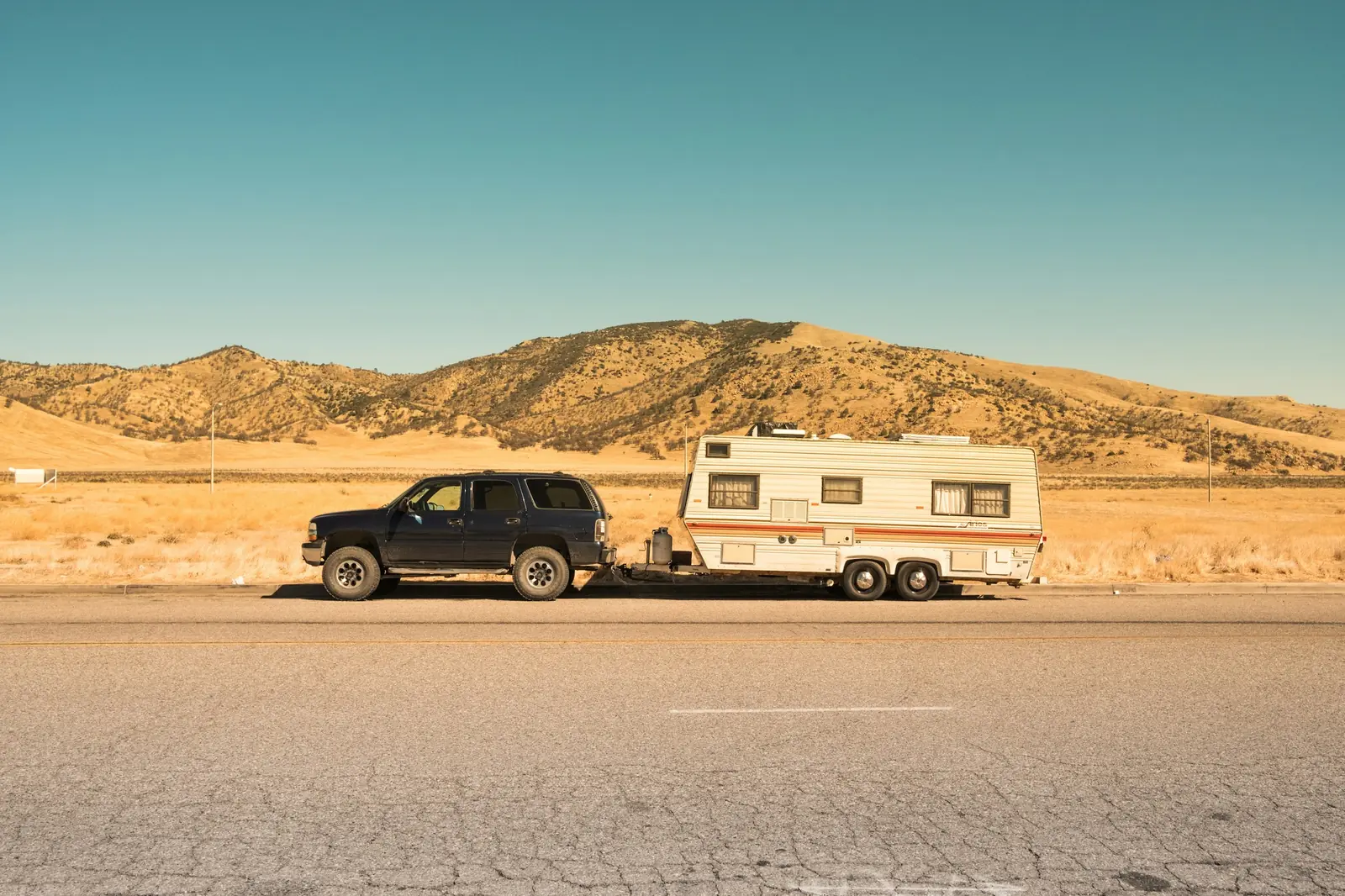 A travel trailer standing on an open grass field